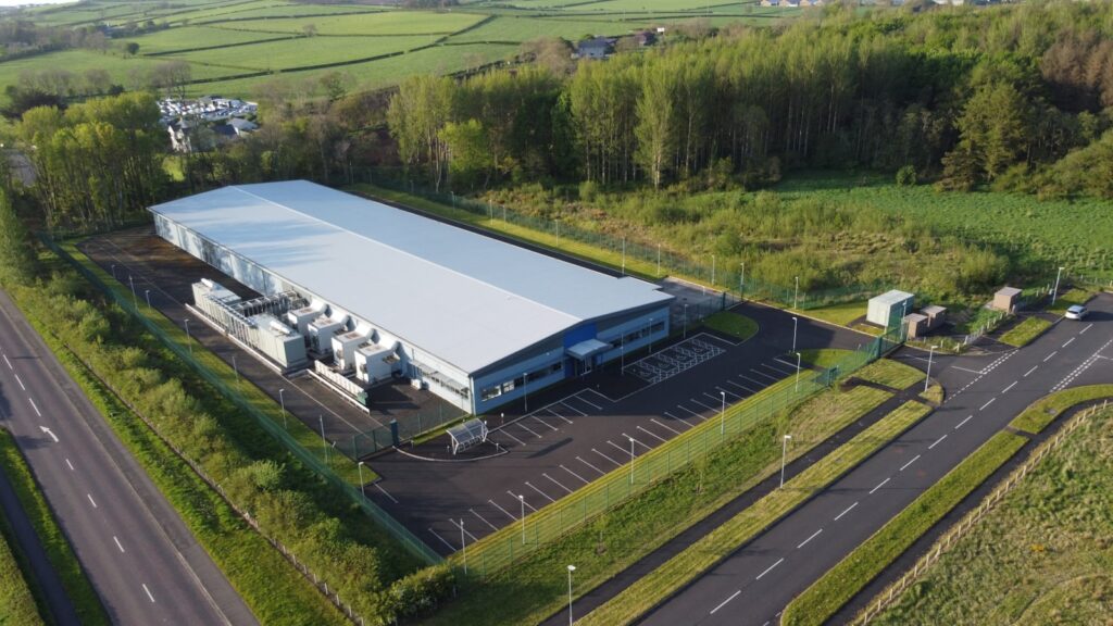 Aerial view of a data center building set in green Nordic landscape